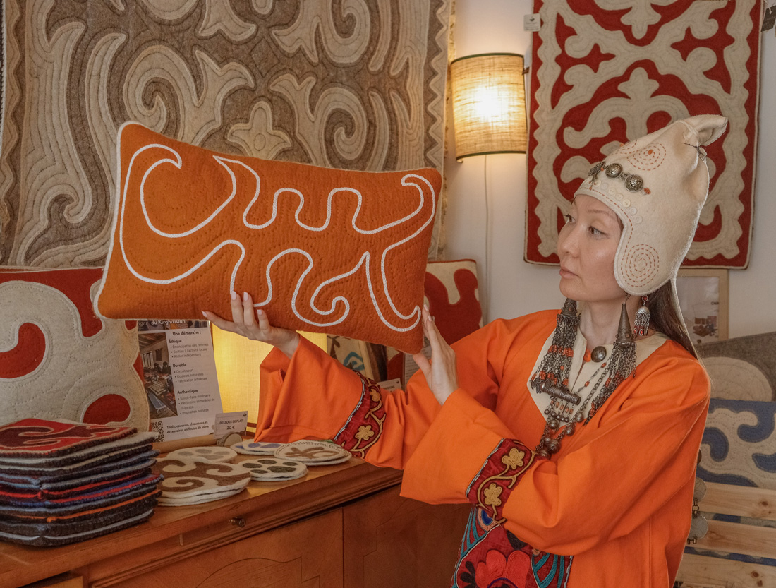 Coussin orange en feutre présenté par une personne
