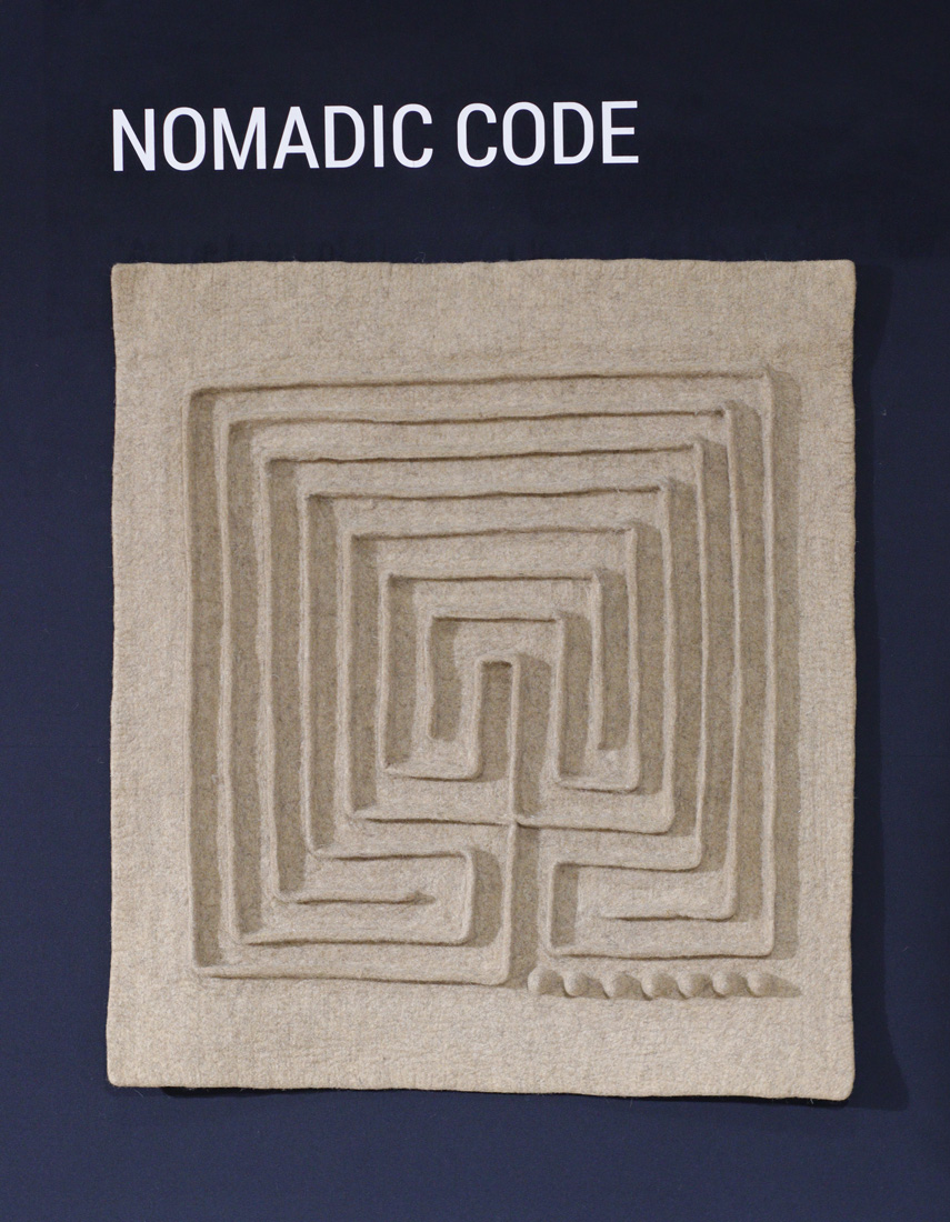 Détail de formes nouées et de pompons en feutre gris et brun