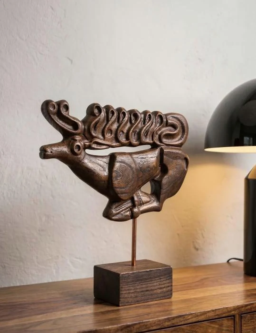 Sculpture en bois présentée sur un meuble dans un intérieur